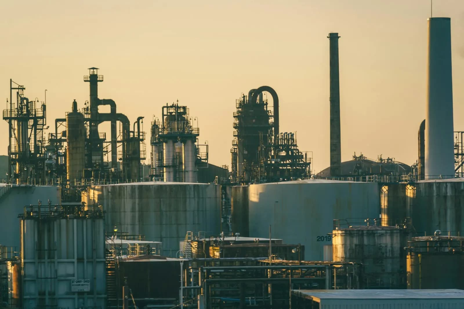 Refinería con tanques de almacenamiento y racks de tubería
